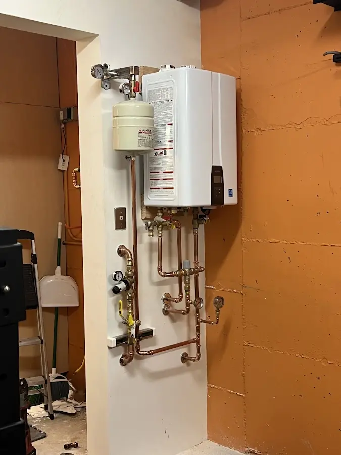 Plumbing technician inspecting water heater connections in Two Harbors